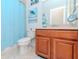 Bathroom featuring tiled floor, vanity with wood cabinets, toilet, and blue mermaid-themed decor at 4210 Overture Cir, Bradenton, FL 34209