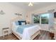 Cozy bedroom with a queen-size bed, wood floors, and palm tree view from the window at 4210 Overture Cir, Bradenton, FL 34209