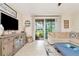 Inviting living room with neutral tones, tile flooring, entertainment center, and sliding glass doors to screened lanai at 4210 Overture Cir, Bradenton, FL 34209