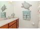 Bathroom with a single vanity, a large mirror, and seashell themed decor at 4210 Overture Cir, Bradenton, FL 34209