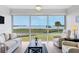 Bright living room featuring large windows with water views, neutral furniture, and wood flooring at 4753 Independence Dr, Bradenton, FL 34210
