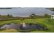 Scenic view of a pond with a fountain, surrounded by green space and palm trees in the community at 4753 Independence Dr, Bradenton, FL 34210