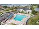 Aerial view of a community pool surrounded by lounge chairs, landscaping, and a nearby building at 4753 Independence Dr, Bradenton, FL 34210
