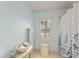 Bright bathroom with tile flooring, shuttered window, and shower with leaf curtain at 4871 Hoyer Dr, Sarasota, FL 34241
