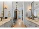 Luxurious dual vanity bathroom with marble countertops, elegant lighting, and a glass enclosed shower at 4871 Hoyer Dr, Sarasota, FL 34241
