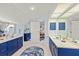 Elegant bathroom featuring double sinks, marble countertops, and stylish blue cabinets at 4871 Hoyer Dr, Sarasota, FL 34241