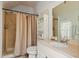 Cozy bathroom featuring a shower with beige curtain, white vanity with sink, and storage shelves at 4871 Hoyer Dr, Sarasota, FL 34241