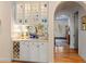 Hallway wet bar area with glass door cabinets, wine rack and view of the front door at 4871 Hoyer Dr, Sarasota, FL 34241