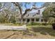 Lovely two-story home with front porch, framed by mature trees and beautiful landscaping at 4871 Hoyer Dr, Sarasota, FL 34241