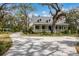 Beautiful two-story home with inviting front porch, set amidst lush landscaping and mature trees at 4871 Hoyer Dr, Sarasota, FL 34241