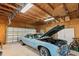 Spacious garage with wood paneling, exposed ceiling beams, and a classic car, ideal for hobbyists at 4871 Hoyer Dr, Sarasota, FL 34241