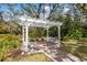 Charming gazebo with benches and potted plants, offering a tranquil outdoor seating area amid lush landscaping at 4871 Hoyer Dr, Sarasota, FL 34241