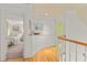 Hallway showcasing hardwood floors, art, and an open doorway to a sunlit bedroom at 4871 Hoyer Dr, Sarasota, FL 34241
