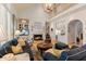 A spacious living room features a fireplace, unique chandelier and staircase to second floor at 4871 Hoyer Dr, Sarasota, FL 34241