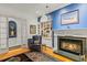 A living room with a fireplace, built-in bookshelves, blue accent wall, and classic decor at 4871 Hoyer Dr, Sarasota, FL 34241