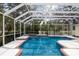 Enclosed swimming pool featuring sun-drenched and refreshing waters, surrounded by lush foliage at 4871 Hoyer Dr, Sarasota, FL 34241