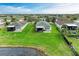 Aerial view of a home showcasing the expansive green lawn, patio, and lake view at 5015 98Th E Ave, Parrish, FL 34219
