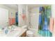 Well-lit bathroom featuring a vanity, bath tub, and vibrant shower curtain at 5015 98Th E Ave, Parrish, FL 34219
