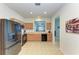 Open-concept kitchen with stainless steel refrigerator and oak cabinets at 5015 98Th E Ave, Parrish, FL 34219