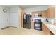 Kitchen with modern black appliances, oak cabinetry, and ample storage space at 5015 98Th E Ave, Parrish, FL 34219