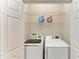 Convenient laundry room with modern washer and dryer, plus storage shelving for supplies at 5015 98Th E Ave, Parrish, FL 34219
