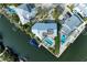 Aerial view of the waterfront home, pool, boatlift, and lush landscape at 511 Loquat Dr, Anna Maria, FL 34216