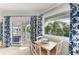Sunlit breakfast nook features blue and white curtains with canal views at 511 Loquat Dr, Anna Maria, FL 34216