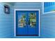 A close-up of striking blue double doors with glass panels, framed by crisp white trim and blue siding at 511 Loquat Dr, Anna Maria, FL 34216
