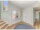 Light-filled entryway with double doors, hardwood floors, and a staircase leading to the upper level at 511 Loquat Dr, Anna Maria, FL 34216
