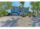 A charming coastal home with a two-car garage, staircase, and tropical landscaping at 511 Loquat Dr, Anna Maria, FL 34216