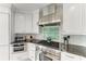 Up close view of kitchen with stainless steel oven and range hood, with brick backsplash at 511 Loquat Dr, Anna Maria, FL 34216