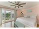 Spacious main bedroom with balcony access, complemented by pink walls and a ceiling fan at 511 Loquat Dr, Anna Maria, FL 34216
