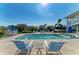 Beautiful waterfront pool area features a sparkling pool, spa, and lounge seating with a view of the canal at 511 Loquat Dr, Anna Maria, FL 34216