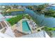 Aerial view of a private swimming pool with lounge chairs next to a serene waterway at 511 Loquat Dr, Anna Maria, FL 34216