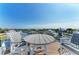 Relaxing rooftop deck showcasing a round dining table and chairs overlooking tranquil waters at 511 Loquat Dr, Anna Maria, FL 34216