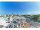 Inviting rooftop deck with white railings and dining area with waterway views at 511 Loquat Dr, Anna Maria, FL 34216