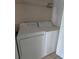 Bright laundry room with modern white washer and dryer, plus wire shelving for added storage space at 5168 Northridge Rd # 102, Sarasota, FL 34238