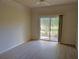 Bright living room with wood-look floors, ceiling fan, and sliding glass doors with a view of greenery at 5168 Northridge Rd # 102, Sarasota, FL 34238