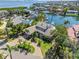 Stunning aerial view of a waterfront property with lush landscaping, pool, boat dock, and city views at 520 Harbor Cay Dr, Longboat Key, FL 34228