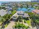 Waterfront property featuring lush landscaping, a large driveway, and views of the canal at 520 Harbor Cay Dr, Longboat Key, FL 34228