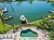 Stunning aerial view showcases the pool, boat dock, and waterfront setting of this luxurious home at 520 Harbor Cay Dr, Longboat Key, FL 34228