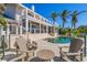 Resort-style backyard with a sparkling pool, multiple seating areas, and lush tropical landscaping at 520 Harbor Cay Dr, Longboat Key, FL 34228