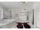 Bright bathroom featuring a soaking tub, glass enclosed shower, double vanity sinks, and neutral color palette at 520 Harbor Cay Dr, Longboat Key, FL 34228