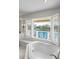 Bathroom showcasing a soaking tub under a window with shutter, along with other stylish accents at 520 Harbor Cay Dr, Longboat Key, FL 34228