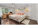 Bright bedroom features wood floors, desk, ceiling fan, and decorative lighting at 520 Harbor Cay Dr, Longboat Key, FL 34228