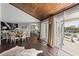 Sunlit dining room with wood floors and doors leading to patio with canal views at 520 Harbor Cay Dr, Longboat Key, FL 34228
