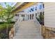 Elegant entrance featuring stone steps, white railings, and a well-manicured garden leading to the front door at 520 Harbor Cay Dr, Longboat Key, FL 34228