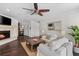Elegant living room features a fireplace, ceiling fan, and comfortable white sofas, creating an inviting atmosphere at 520 Harbor Cay Dr, Longboat Key, FL 34228