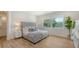 A modern bedroom with a tufted headboard, wood floors, and bright light at 6136 Hollywood Blvd, Sarasota, FL 34231