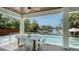 Covered lanai featuring a dining table with views of the pool and canal at 6136 Hollywood Blvd, Sarasota, FL 34231